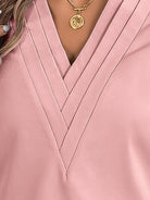 White pleated V-neck long-sleeve blouse with diagonal pleated panel and button cuffs