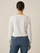 White pleated V-neck long-sleeve blouse with button cuffs and relaxed fit