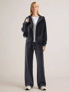 Woman wearing chenille zip-up hoodie and wide-leg pants loungewear set in soft fabric with drawstring waist and side pockets