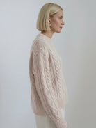 Oversized cable-knit crewneck sweater with dropped shoulders and textured diamond and rope pattern