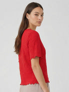 Floral jacquard pleated top with 3D floral texture and flutter sleeves in relaxed A-line silhouette