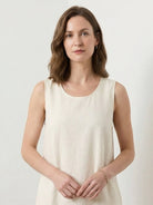 Woman wearing a 100% cotton linen sleeveless maxi dress with a round neckline and flowing ankle-length silhouette