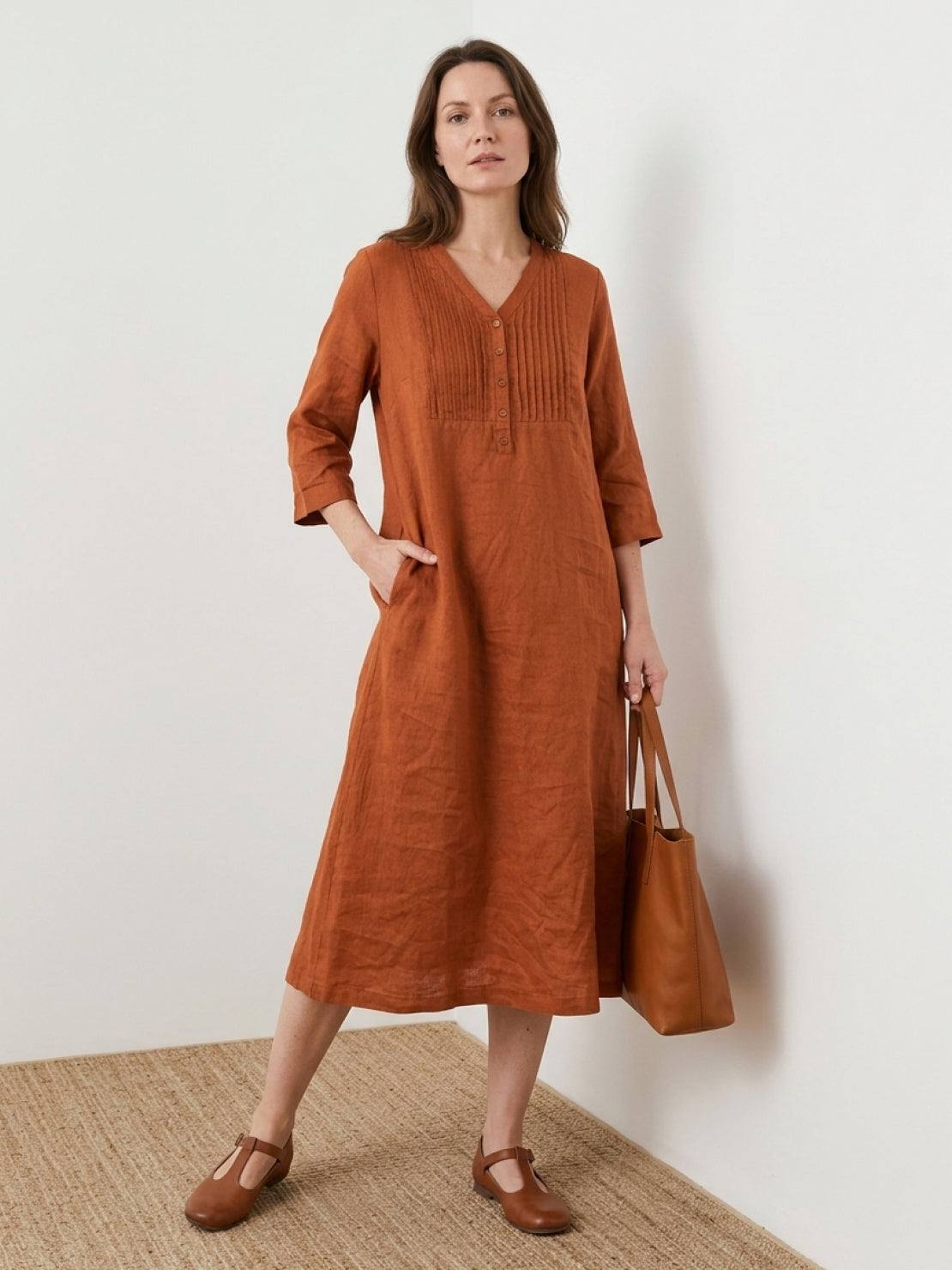 Relaxed A-line cotton linen dress with vertical pintuck pleats, 3/4 sleeves, side slits, and breathable fabric for all-day comfort