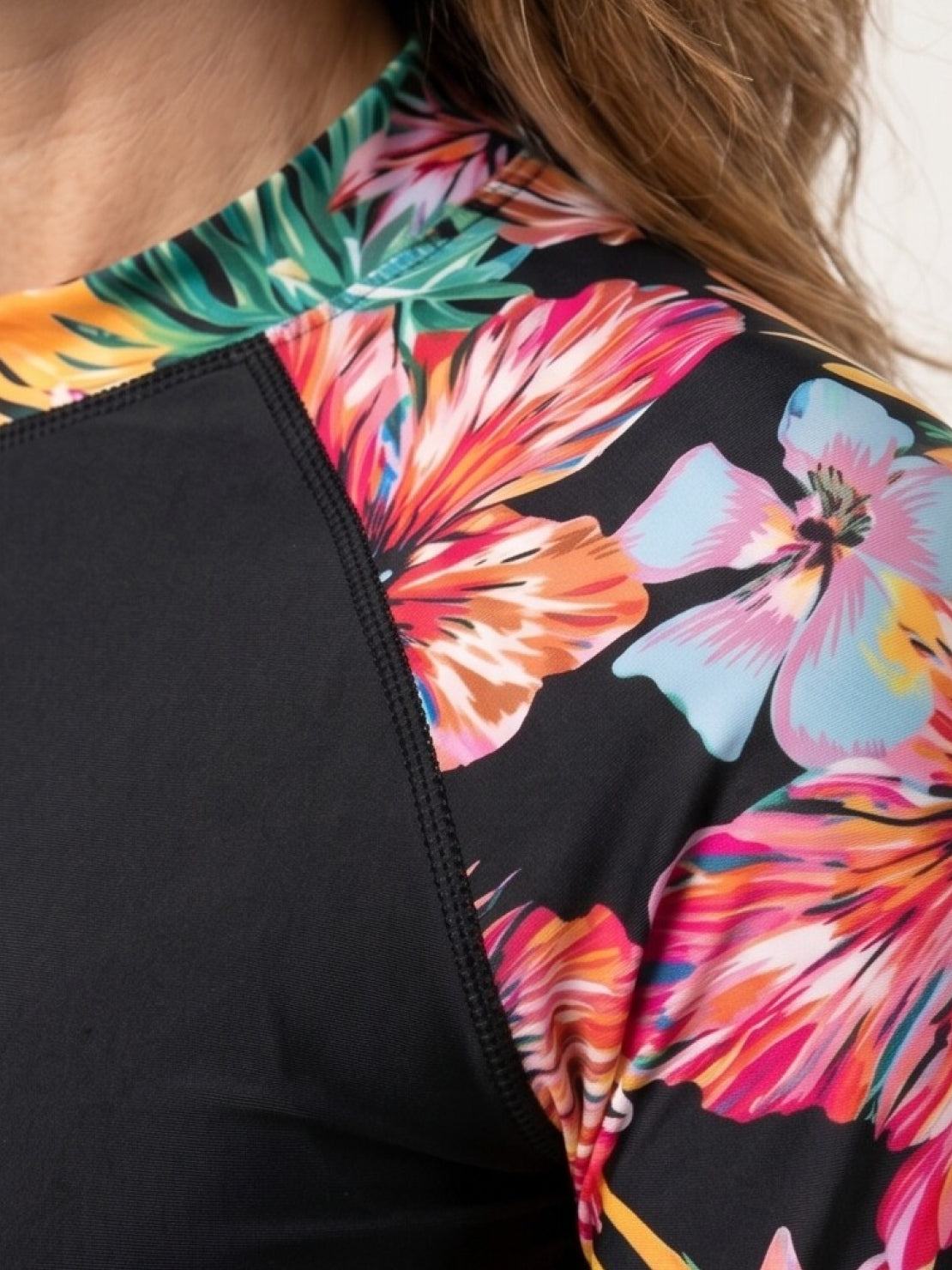 Two-piece tropical print rash guard set with long-sleeve top and matching boy-cut swim shorts