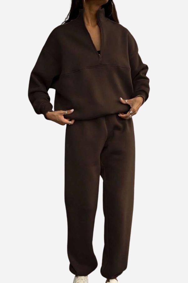 Woman wearing a comfortable cotton-blended two-piece tracksuit with high collar and deep zipper in a monochrome design