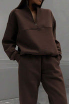 woman wearing cotton-blended two-piece tracksuit with high collar and zipper in monochrome design