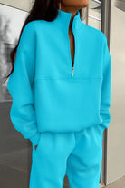 Woman wearing a soft cotton-blended two-piece monochrome tracksuit with high collar and zipper