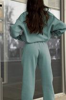 Woman wearing a comfortable cotton-blended two-piece tracksuit with high collar and deep zipper in a monochrome relaxed fit