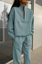 Woman wearing a comfortable cotton-blended two-piece tracksuit with high collar and zipper in monochrome design