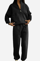 woman wearing a cotton-blended two-piece tracksuit with high collar and zipper in monochrome color