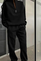 woman wearing cotton-blended two-piece tracksuit with high collar and zipper detailing