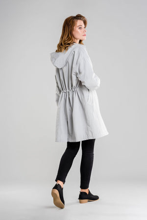 Gray oversized water-resistant windbreaker jacket with hood worn by a woman