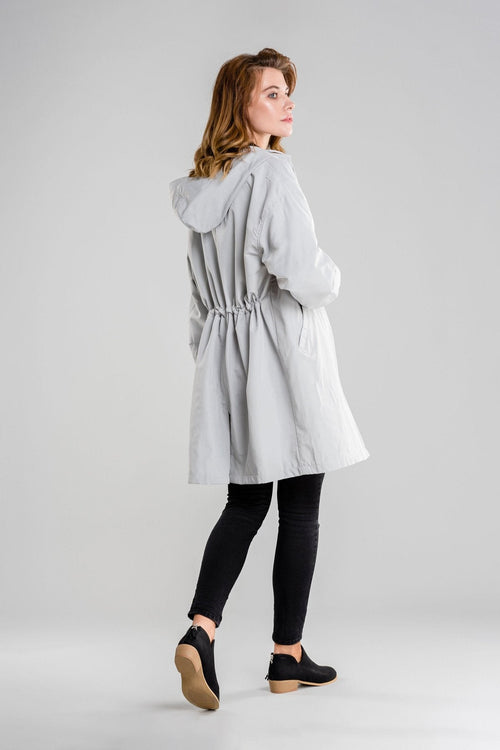Gray oversized water-resistant windbreaker jacket with hood worn by a woman