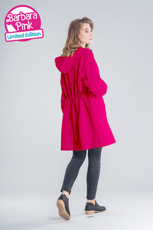 Woman wearing oversized red water-resistant windbreaker with hood and elastic waist