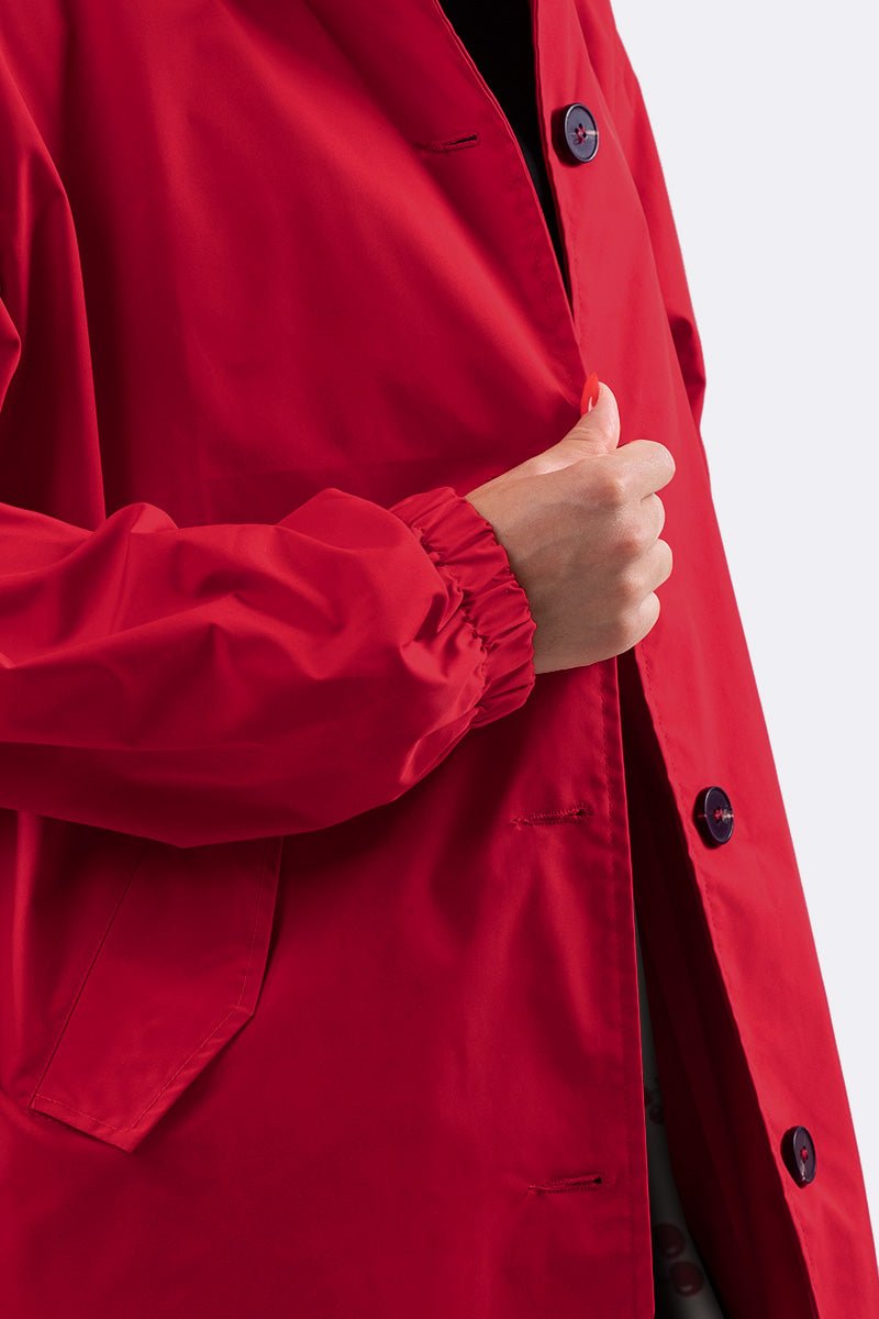 Red water resistant oversized windbreaker with button closure and elastic cuffs.