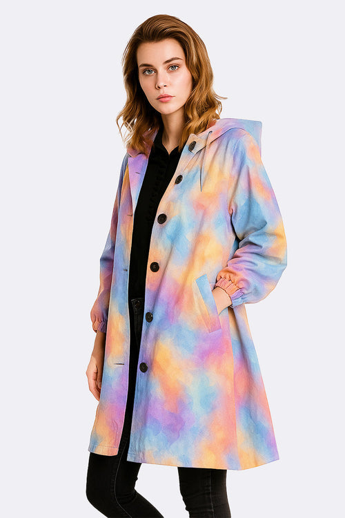 Woman wearing colorful water-resistant oversized hooded windbreaker rain jacket with button closure and side pockets