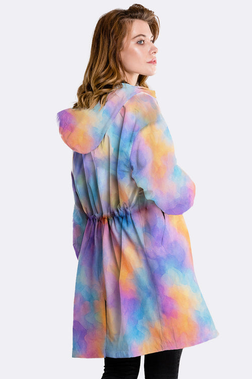 Colorful water-resistant windbreaker jacket with oversized fit and hood worn by woman from back side