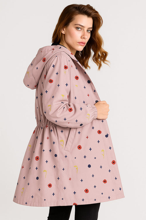 Water-resistant oversized hooded windbreaker jacket with colorful pattern on pink fabric worn by woman