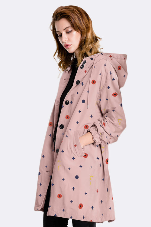 Woman wearing pink water-resistant windbreaker with hood and multicolor patterns