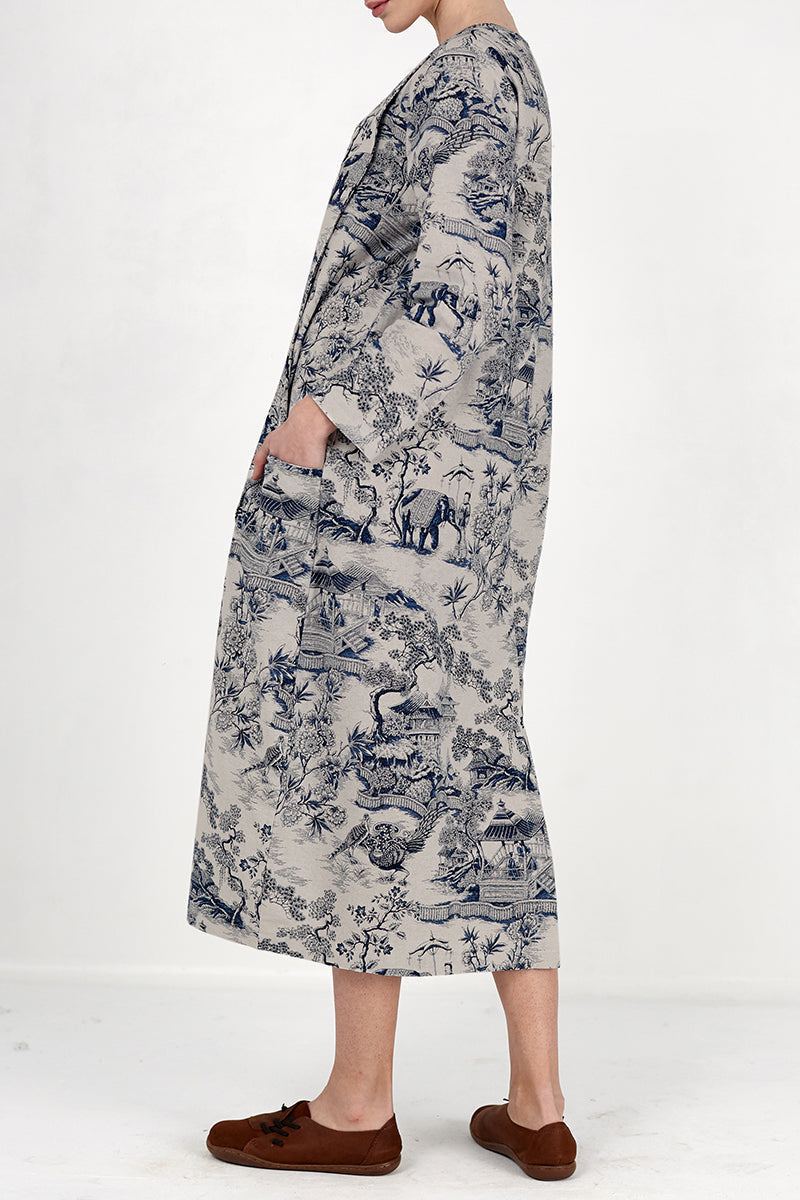 Side view of a woman wearing a Japanese Porcelain Print midi dress with 3/4 sleeves and oversized pockets in cozy blue patterned fabric