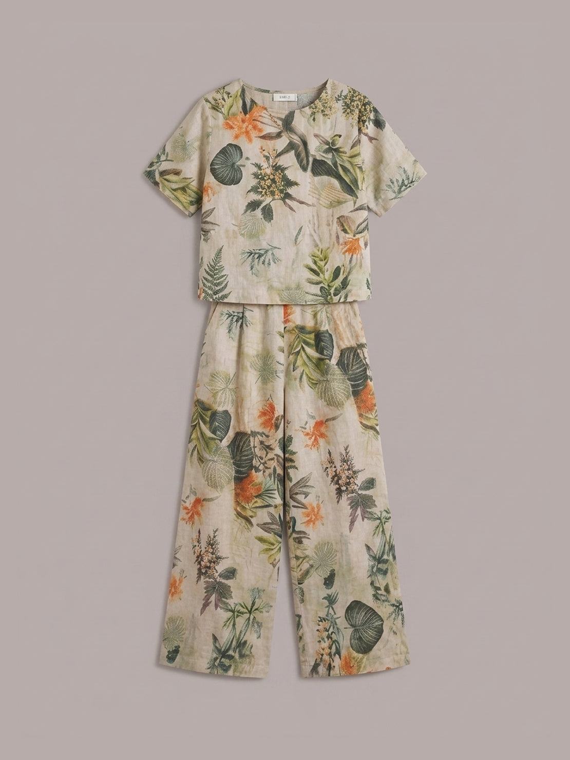 Woman wearing a soft cotton loose fit co-ord set with a relaxed short-sleeve top and wide-leg trousers against white background
