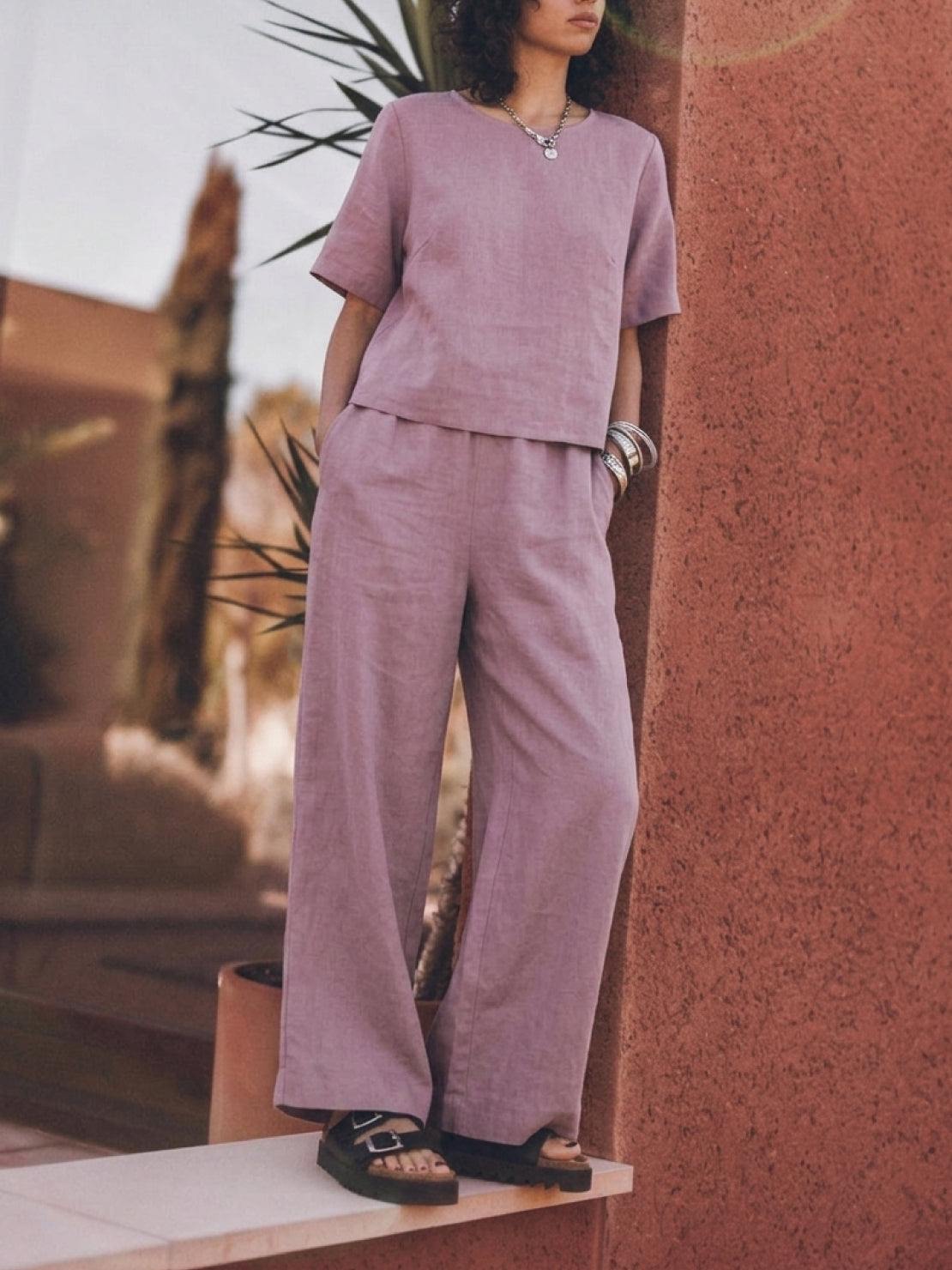 woman wearing light beige loose fit co-ord set with short sleeves and wide-leg trousers in relaxed pose