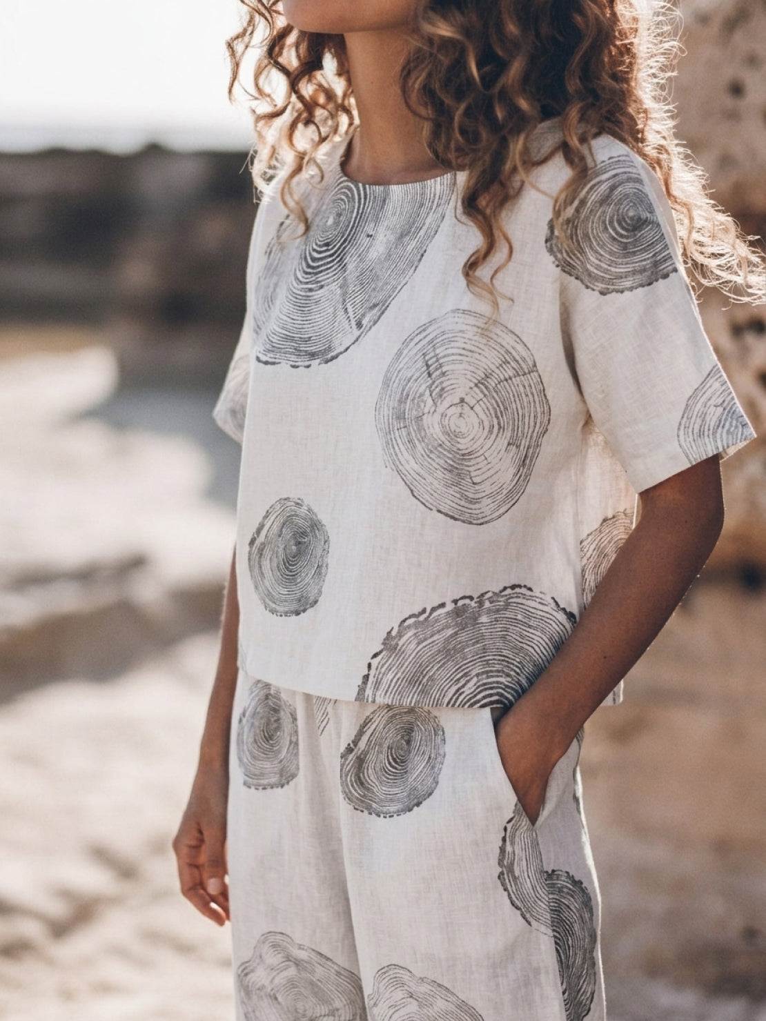 Model wearing a soft-tailored loose fit co-ord set with wide sleeves and wide-leg cotton trousers in light neutral color