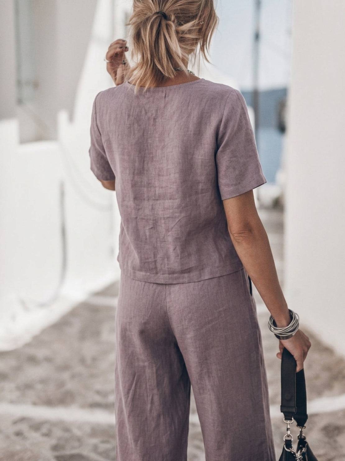 Woman wearing a soft cotton loose fit co-ord set with relaxed top and wide-leg bottoms in a light neutral color