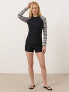 Swim shorts rash guard set with long raglan sleeves and matching printed boyshort bottoms on white background
