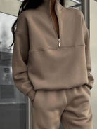 woman wearing cotton-blended two-piece tracksuit with high collar and zipper