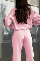 Woman wearing pink Classic Airplane Set tracksuit from the back, featuring relaxed fit pullover and tapered joggers