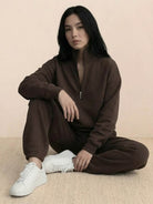 woman wearing cotton-blended two-piece tracksuit with high collar and deep zipper in casual athleisure style