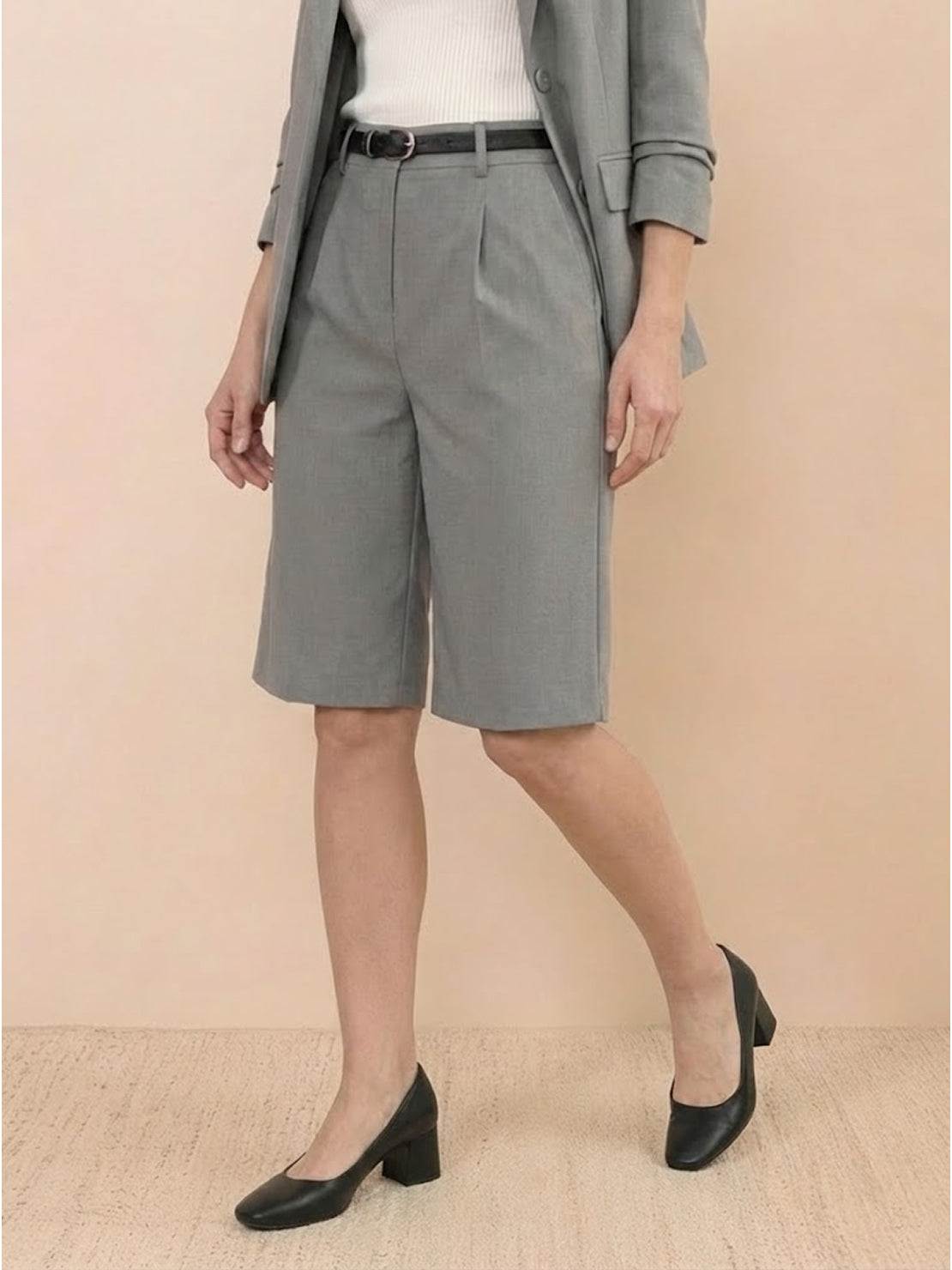 Woman wearing a polished blazer and high-waisted shorts two-piece set in a monochrome outfit