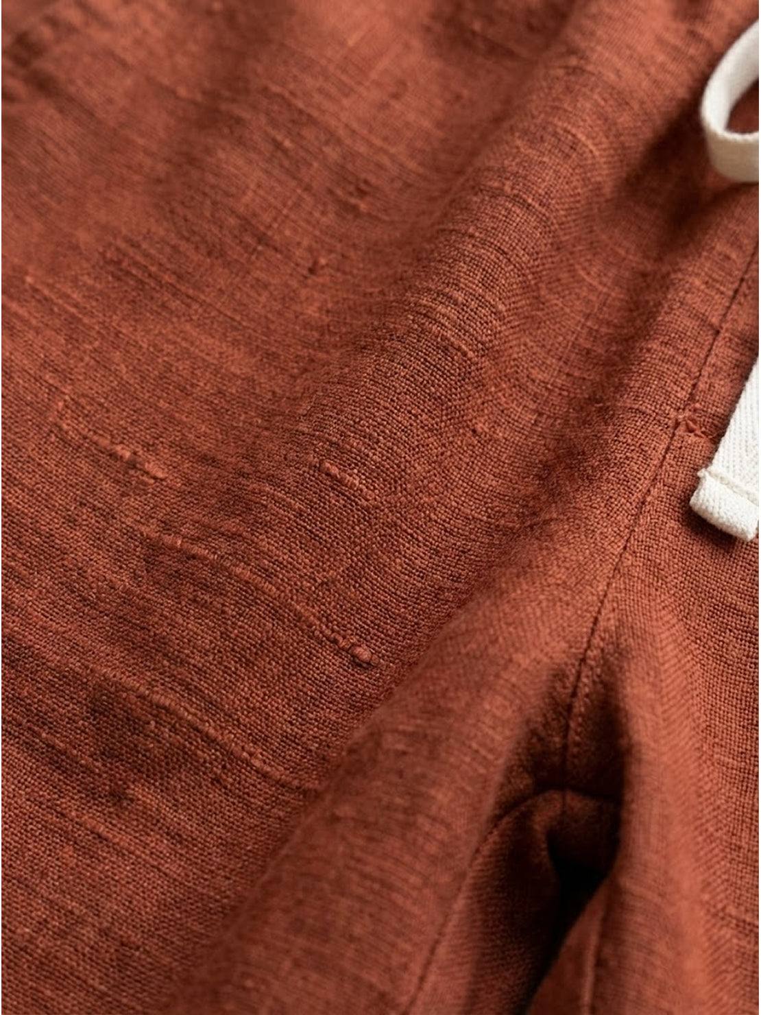 woman wearing orange relaxed fit straight pants standing outdoors with casual shoes