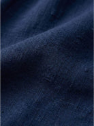 Woman wearing a capped-sleeve voluminous pleated midi dress with pockets and a flowing, stomach-flattening drape