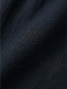 Woman modeling capped-sleeve voluminous pleated midi dress with pockets and flowing silhouette