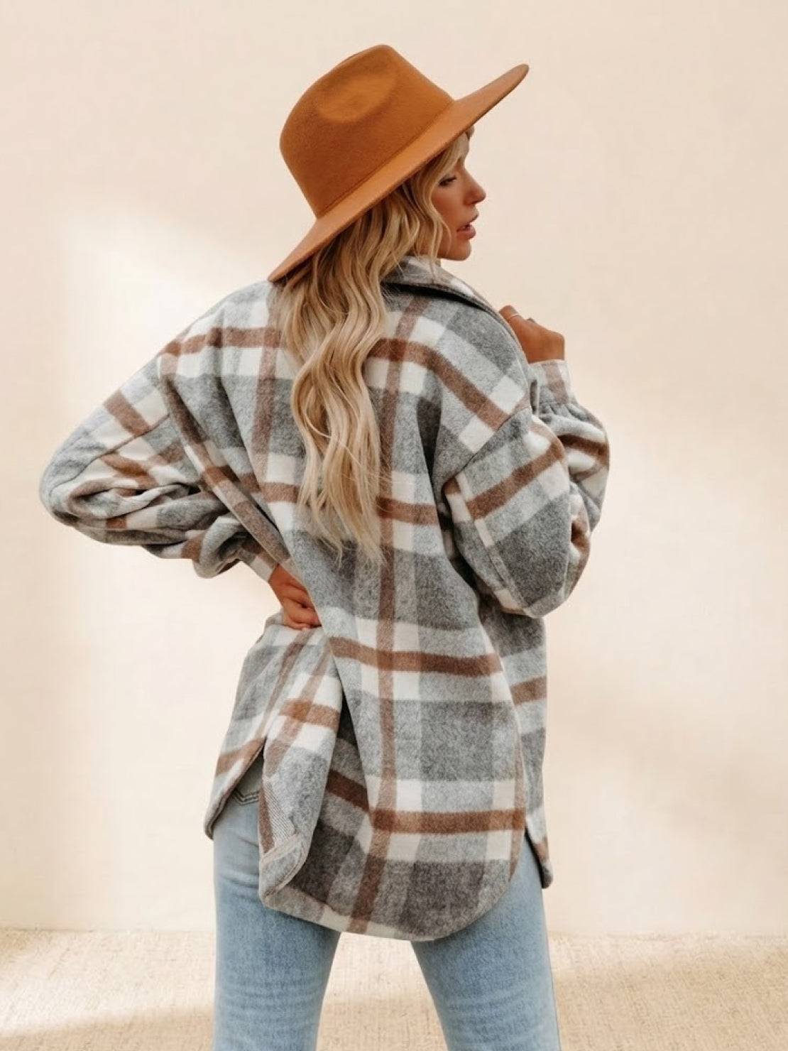 Woman wearing comfy flannel classic button-down shirt with gray and brown plaid pattern and tan hat back view