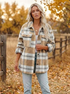 Woman wearing comfy flannel classic button-down shirt in beige and white plaid pattern outdoors in autumn setting