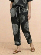 Model wearing relaxed 100% cotton linen set with short-sleeve top and straight-leg pants in monochrome tones