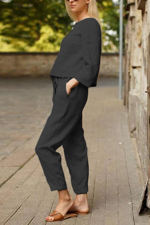 Woman wearing relaxed cotton-linen monochrome longline top and wide-leg pants set with elastic waist and brown slide sandals outdoors