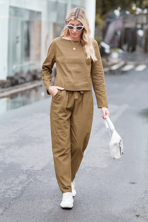 Woman wearing relaxed Cotton-Linen Monochrome monochrome longline top and wide-leg pants with white sneakers and sunglasses walking outdoors
