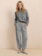 Woman wearing a gray relaxed sweater top and trouser set embodying European Minimalism style
