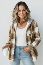 Highland Plaid Shacket with soft fleece lining, hood, and button-front closure in brown and white plaid, styled casually with jeans and a white tank top.