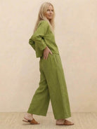 Woman wearing loose solid color green two-piece set with wide-leg pants and long-sleeve top