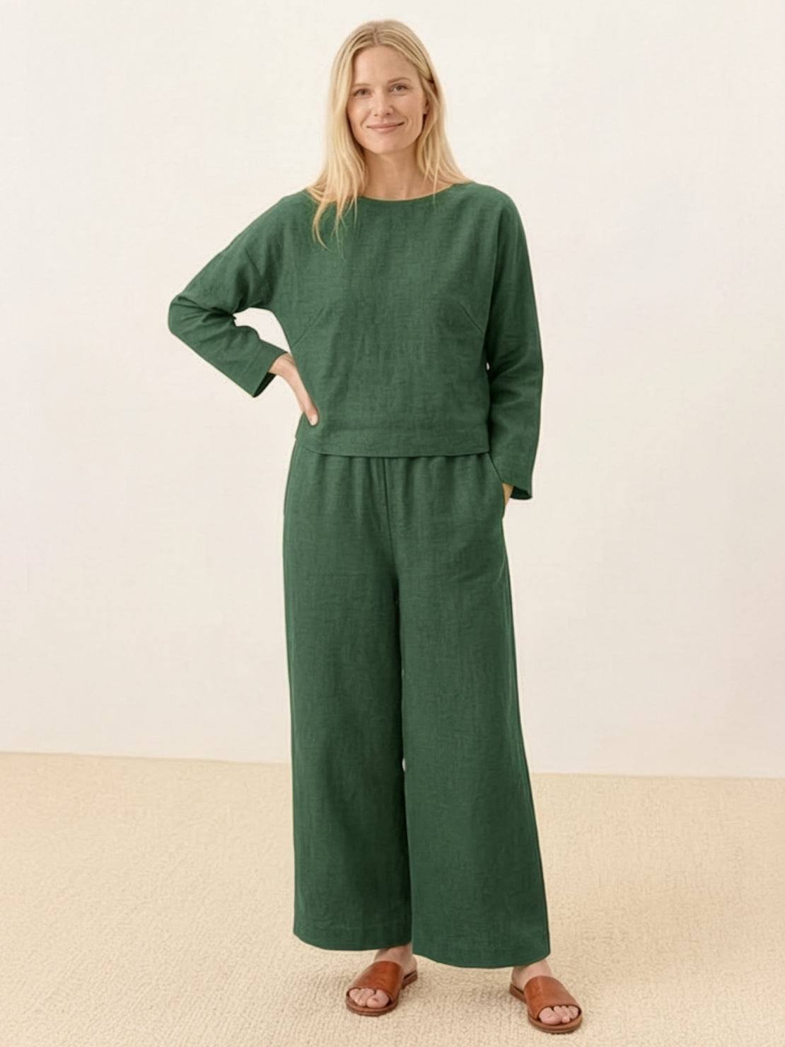 Woman wearing loose solid color two-piece green set with long sleeves and wide-leg pants