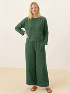 woman wearing loose solid color green two-piece set with long sleeve top and wide-leg pants
