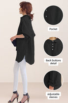 Black oversized linen shirt with back button detail, adjustable sleeves, and relaxed fit worn with white pants and heels.