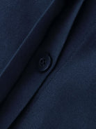 Close-up of oversized 100% cotton navy blue shirt fabric with button detail