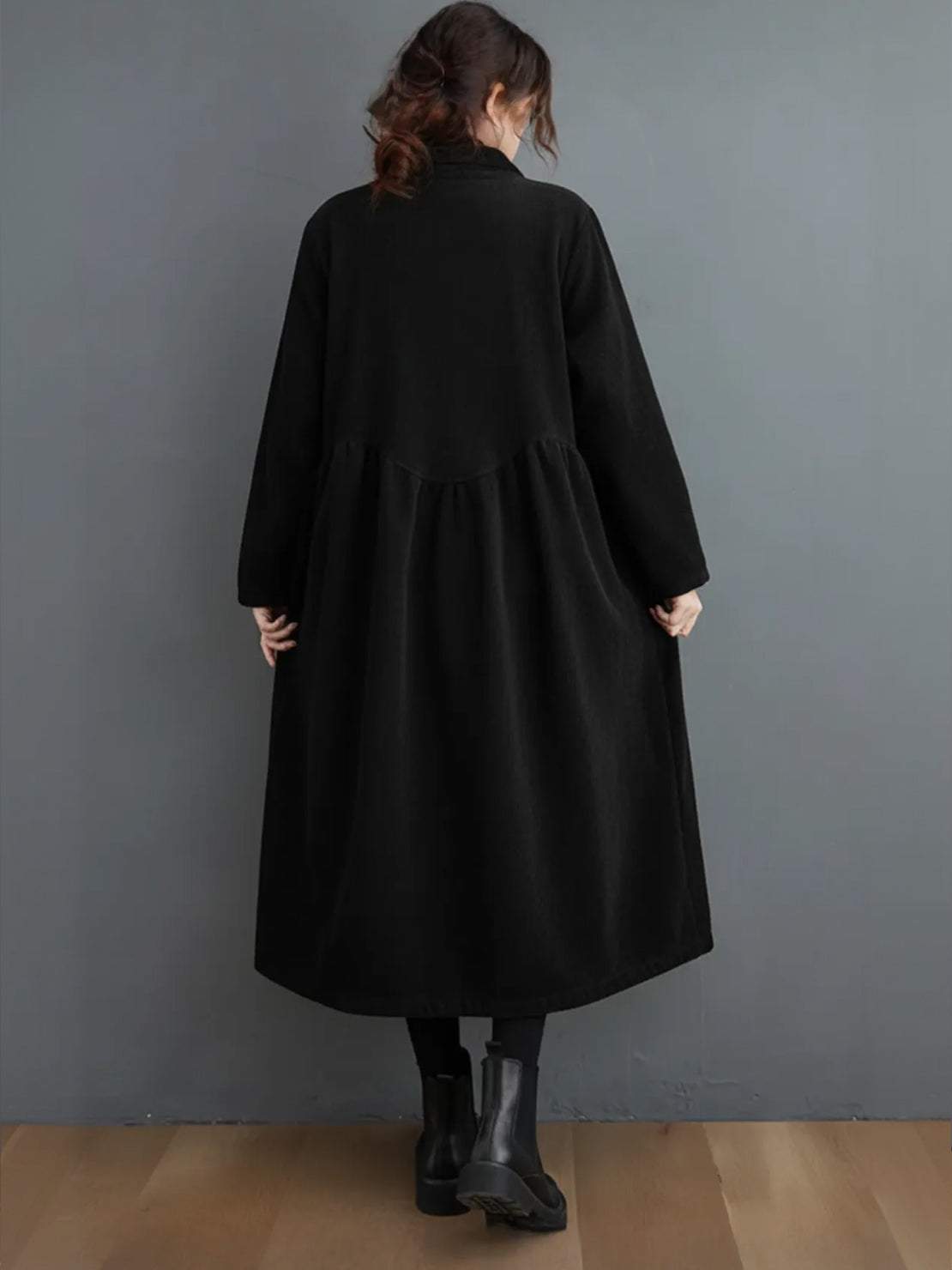 Woman wearing oversized vintage corduroy coat with rich texture and warm earth tones outdoors