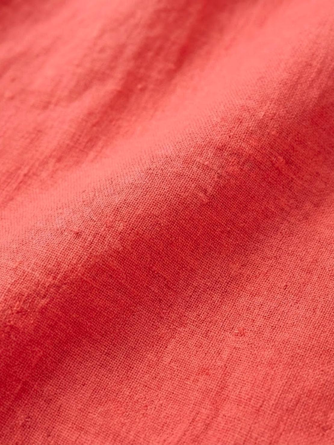 Close-up of coral pure linen fabric texture for age-defying button detail shirt